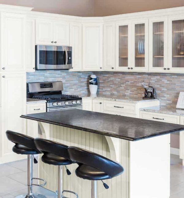 Kitchen with white cabinets and black counter tops, modern design with stainless steel appliances.